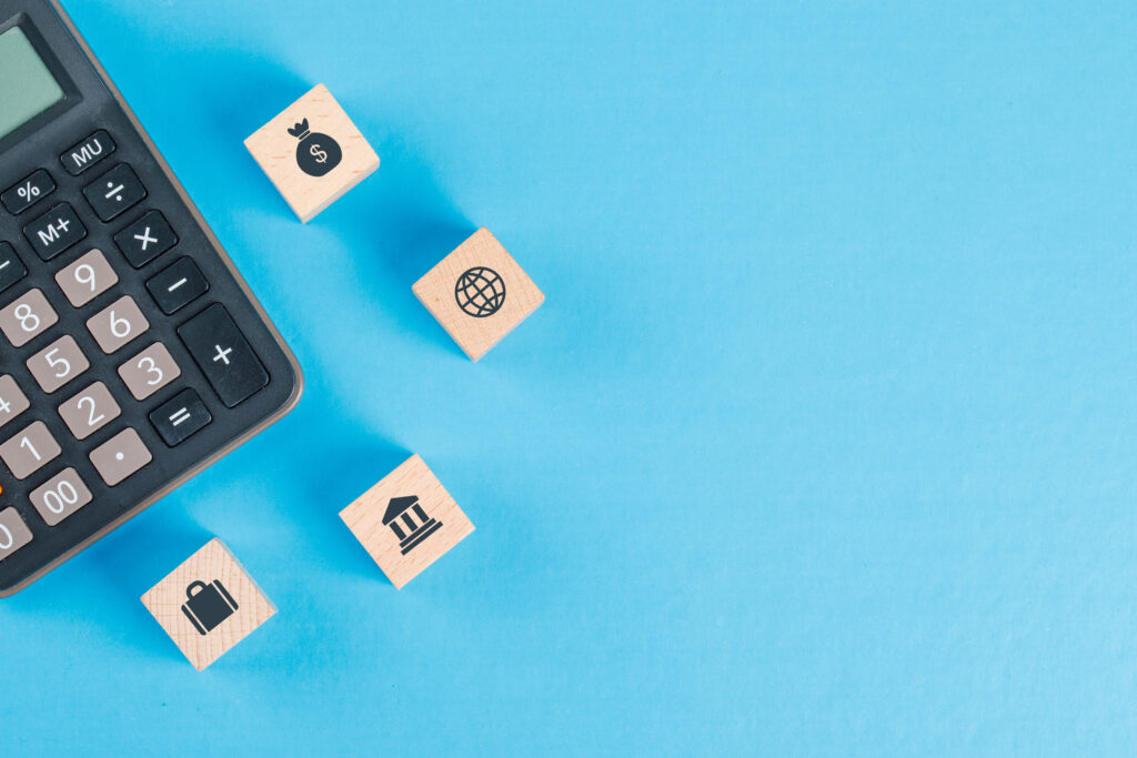 Financial concept with icons on wooden cubes, calculator on blue background flat lay.
